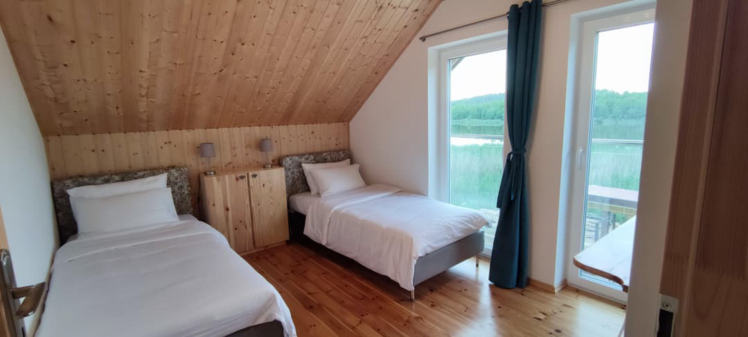 Minimalistycznie urządzony pokój gościnny w Jeziorosferze z naturalnym światłem