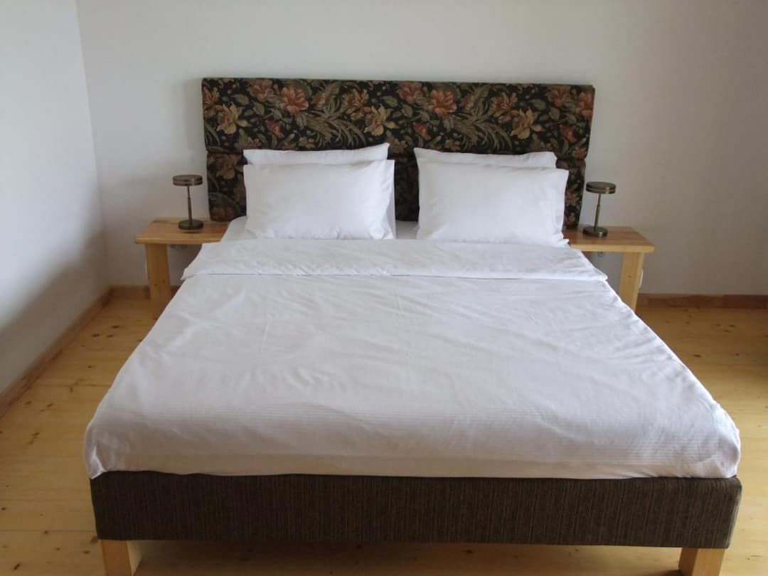 Drewniane detale i komfortowe łóżko w pokoju Jeziorosfery